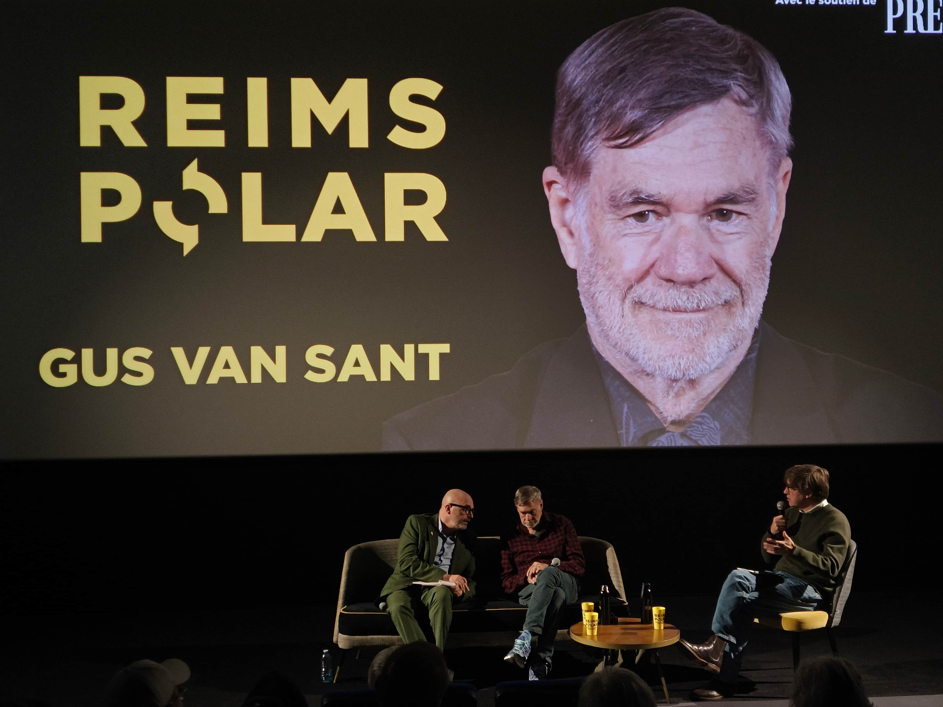 Affiche de « REIMS POLAR » avec le portrait de Gus Van Sant et trois personnes sur scène.