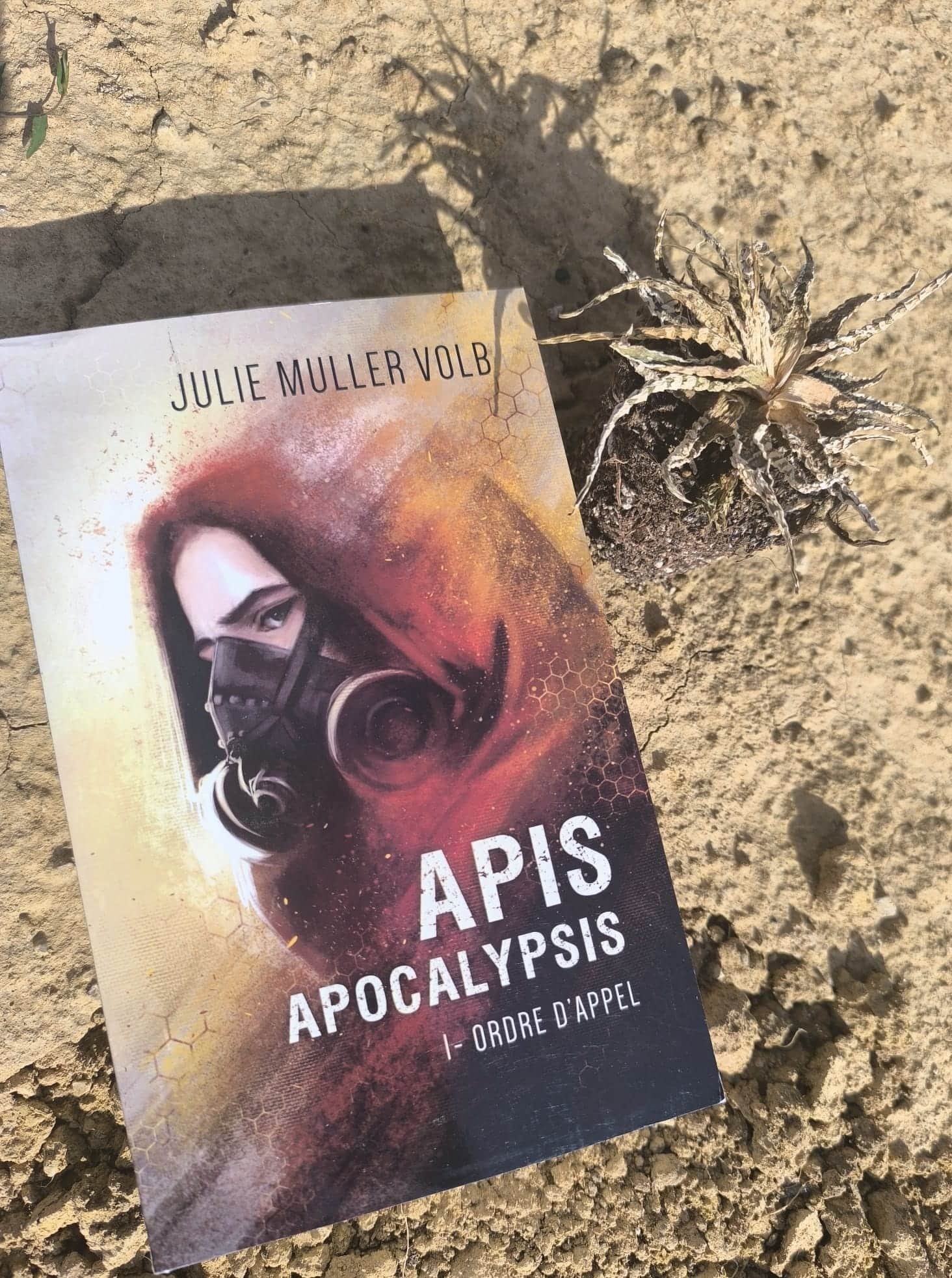 Affiche de « APIS APOCALYPSIS » avec une femme portant un masque à gaz, près d’une plante sèche.