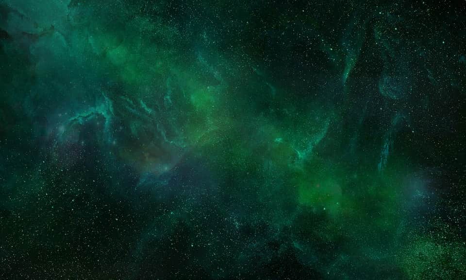 Nébuleuse verte et turquoise parsemée d’étoiles dans l’espace
