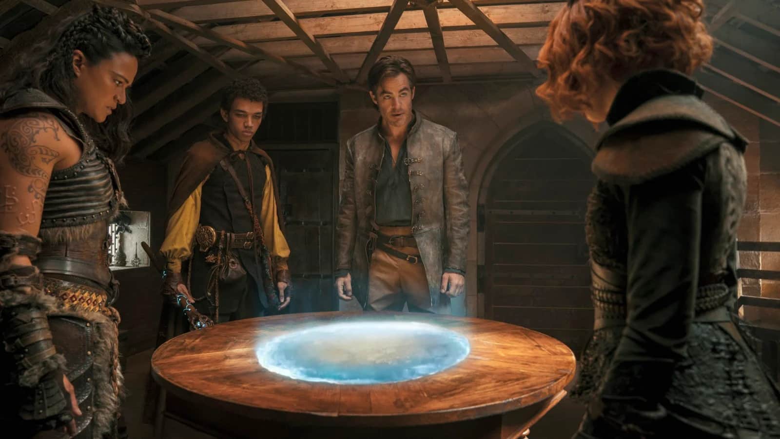 Un groupe de quatre personnes observe une carte lumineuse projetée sur une table en bois.
