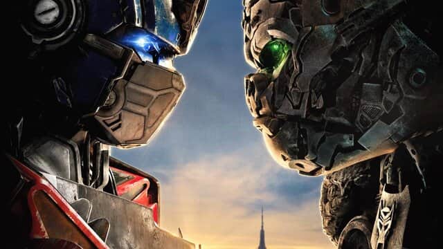 Affiche de « TRANSFORMERS » avec deux robots face à face, l'un avec des yeux bleus et l'autre avec des yeux verts.