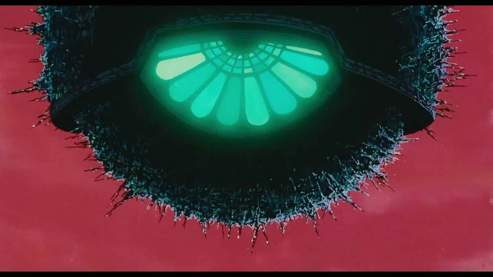 Un disque sombre hérissé de pointes, avec un motif lumineux vert au centre sur fond rouge