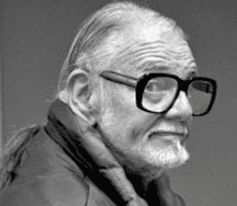 Portrait en noir et blanc d’un homme âgé portant de grandes lunettes noires.