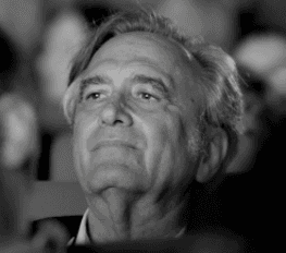 Portrait en noir et blanc d’un homme âgé regardant vers le haut.