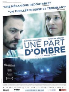 Affiche de « UNE PART D’OMBRE » avec les visages d’un homme et d’une femme au-dessus d’une forêt nocturne.
