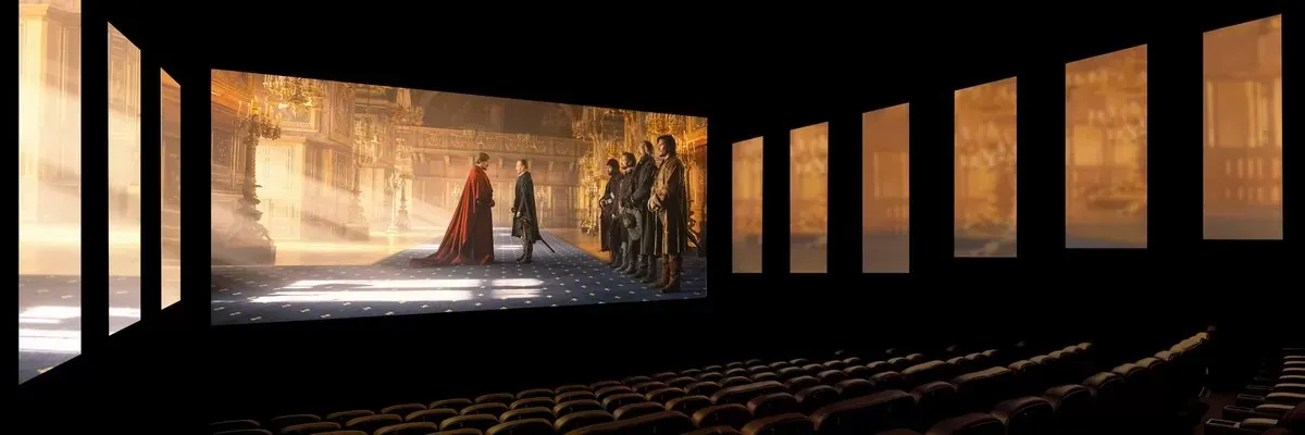 Salle de cinéma aux écrans multiples, projetant une scène médiévale avec un groupe de personnes dans un palais.