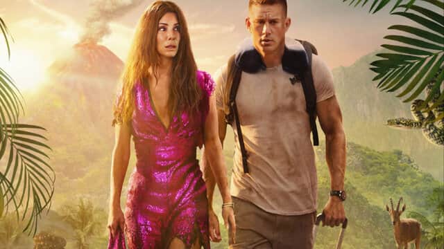 Affiche de « THE LOST CITY » avec une femme en robe rose et un homme avec un sac à dos dans une jungle volcanique.