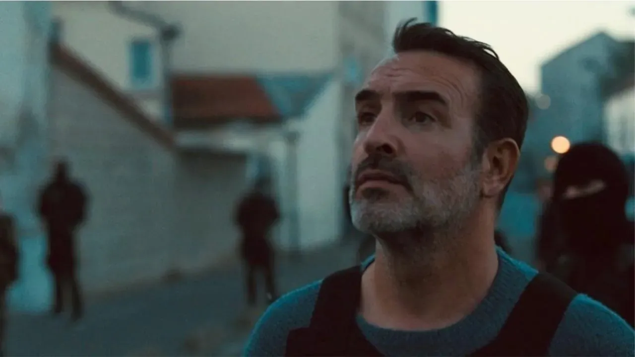 Homme barbu regardant vers le ciel dans une rue urbaine, avec des silhouettes floues en arrière-plan