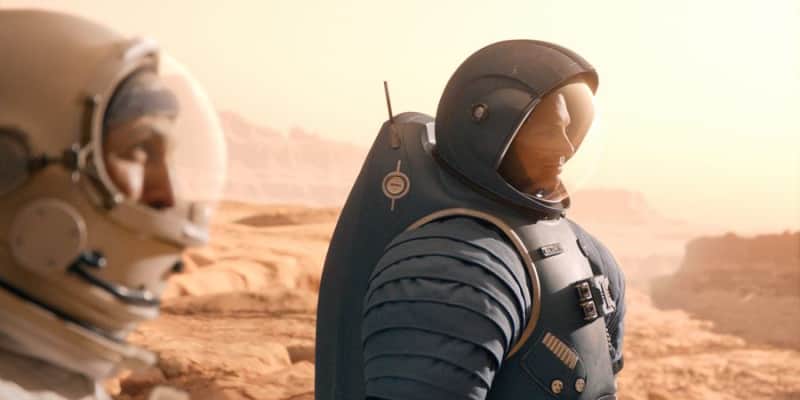 Deux astronautes en combinaison observent un paysage désertique martien.
