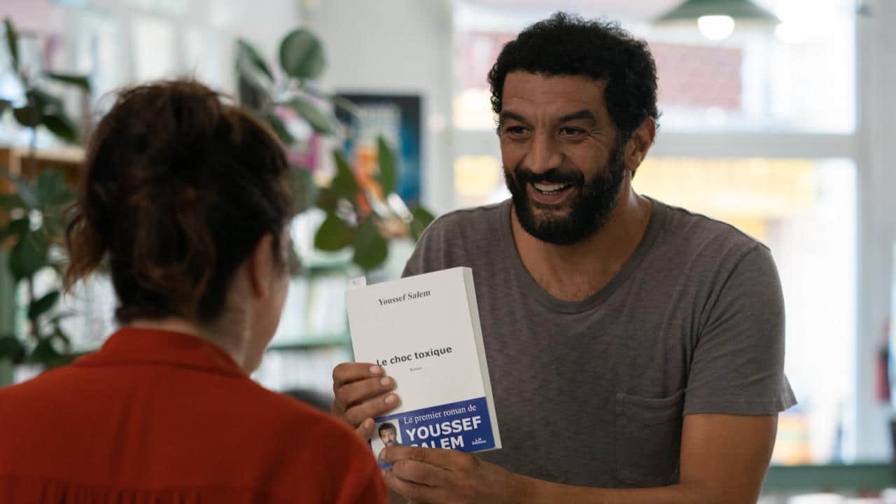Jaquette de « le choc toxique » avec un homme barbu tenant le livre face à une femme.