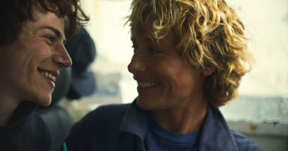 Deux personnes souriantes se regardent dans l’habitacle d’un véhicule.