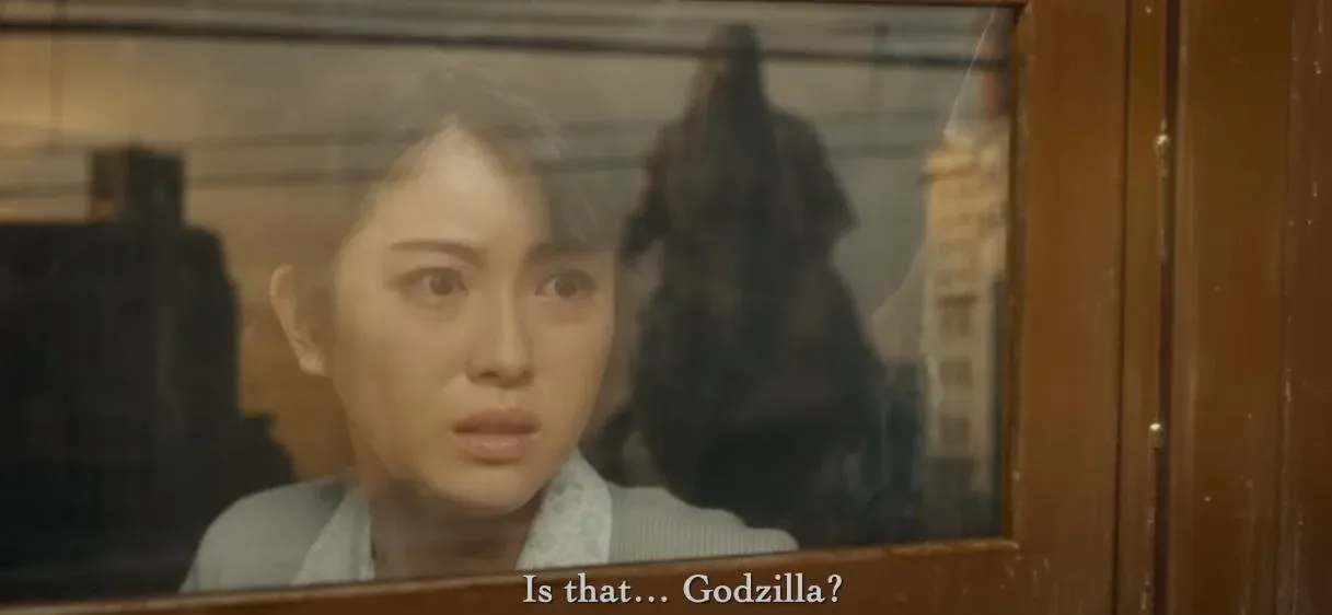 Une femme regarde à travers une vitre, avec le sous-titre « Is that... Godzilla?