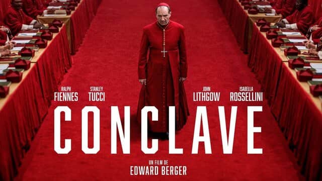 Affiche de « CONCLAVE » avec un homme en robe rouge marchant sur un tapis rouge entouré de cardinaux.