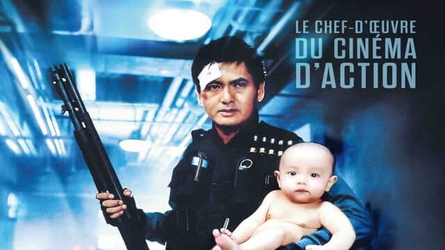Un homme en uniforme tient un bébé et un fusil à pompe, dans un couloir, avec le texte « LE CHEF-D'ŒUVRE DU CINÉMA D'ACTION